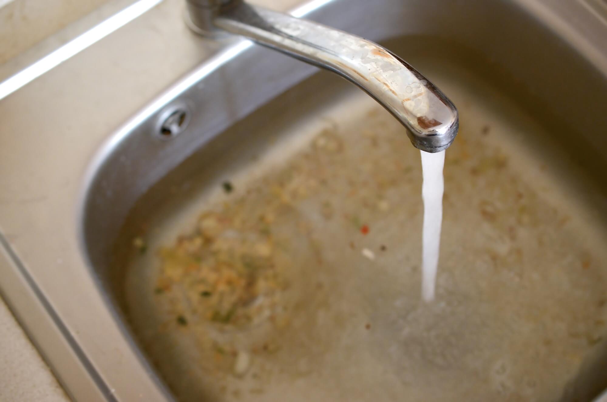 water running in a clogged kitchen drain