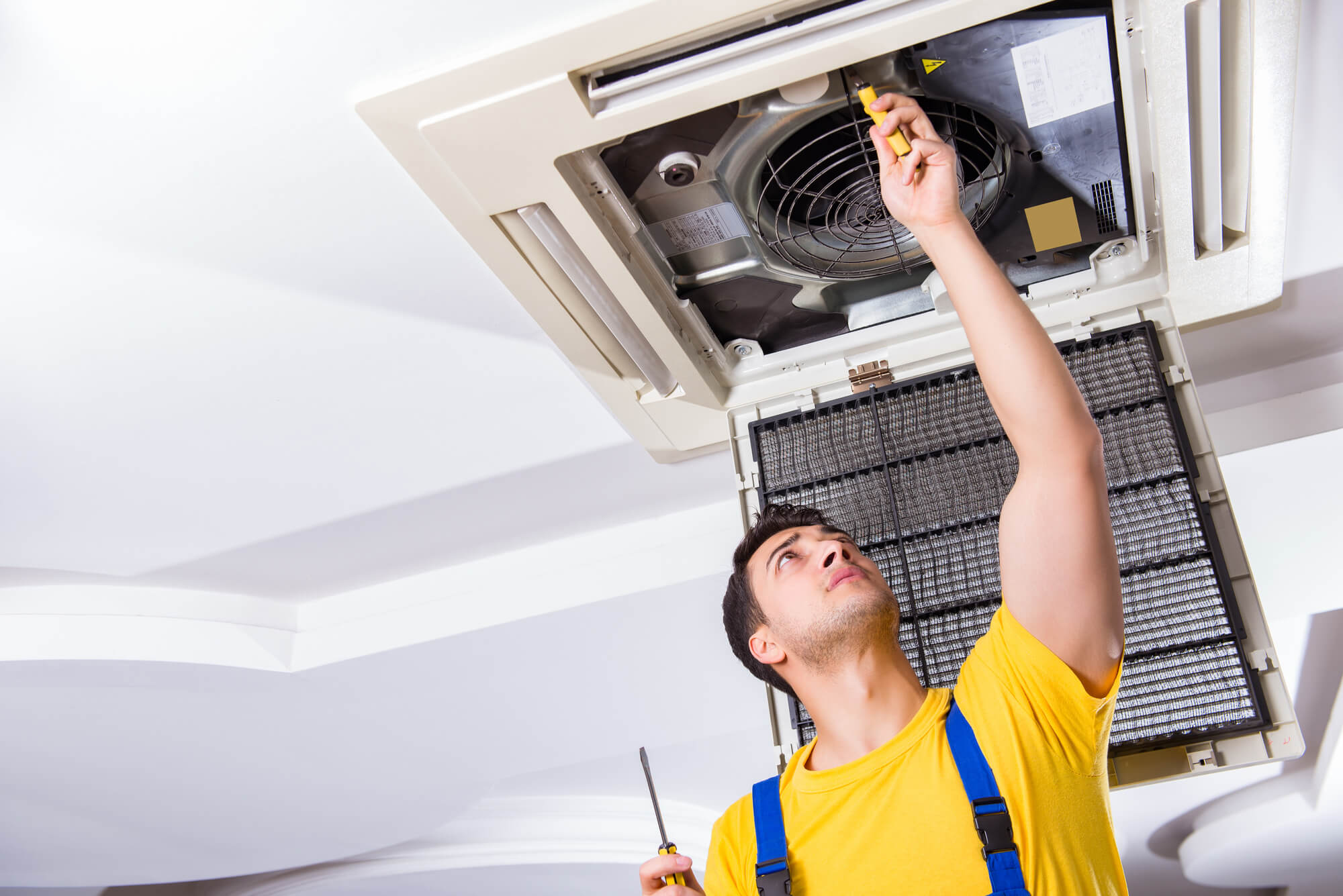 man repairing air conditioning system